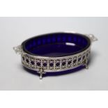 A George V pierced silver oval two handled butter dish, with blue glass liner, Adie Brothers,