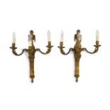 A pair of Louis XVI style ormolu three branch wall lightswith urn crested lion’s mask stems and