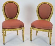 A pair of 19th century Louis XV style giltwood framed side chairs, with oval carved backs, on turned