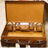 A 1930's Harrods pigskin travelling toilet case with seven engine turned silver fittings,