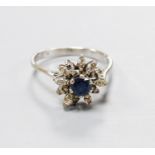An 18ct white metal, sapphire and diamond set flower head cluster ring, size O, gross 3 grams.