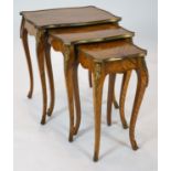 A nest of three Louis XV style ormolu mounted banded kingwood tables, with serpentine sides, on
