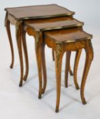 A nest of three Louis XV style ormolu mounted banded kingwood tables, with serpentine sides, on