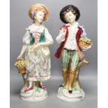 A pair of large Sitzendorf porcelain figures of a maid and a gallant, carrying baskets of fruit52cm