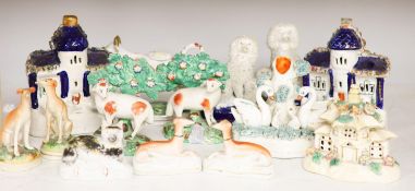 A collection of Victorian Staffordshire pottery to include a sponge glazed seated cat, a pair of