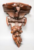 A late 19th century carved mahogany ‘eagle’ wall bracket with glass eyes51cm