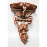 A late 19th century carved mahogany ‘eagle’ wall bracket with glass eyes51cm