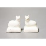 A pair of Staffordshire porcelain models of recumbent kittens, each on a rectangular