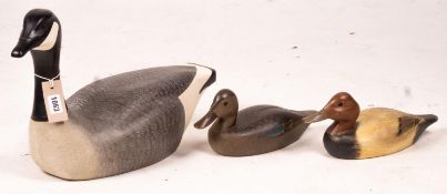 Three American carved and painted decoy duck ornaments, largest 48cm long