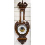 An Edwardian carved walnut cased aneroid barometer and thermometer, height 99cm
