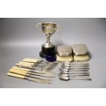 A pair of silver mounted clothes brushes, a silver two handled trophy cup and sundry flatware.