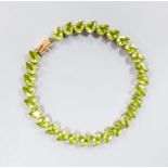 A modern 10k and pear cut peridot set line bracelet, 19cm, gross weight 9.4 grams.