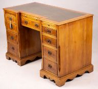 A reproduction yew inverse breakfront kneehole pedestal desk fitted green skiver, width 114cm, depth