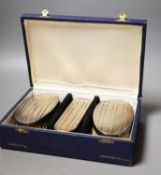 A modern cased silver mounted three piece brush set.