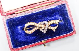 An early 20th century yellow metal, seed pearl and rose cut diamond ribbon and heart brooch, 37mm,