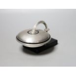 An unusual Art Deco engine turned silver and black enamel circular compact, with support arm, on