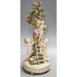 A German porcelain Meissen style group of amorini, climbing a ladder to pick fruit from a tree,