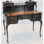 A late Victorian carved mahogany serpentine-shaped writing desk, length 106cm, depth 54cm, height
