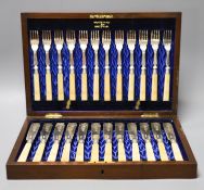 An Edwardian cased set of twelve pairs of ivory handles silver fish eaters, Walker & Hall,