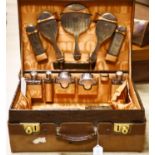 A George V crocodile skin travelling toilet case with ten engine turned silver mounted silver