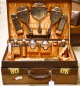 A George V crocodile skin travelling toilet case with ten engine turned silver mounted silver