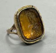 A 19th century yellow metal and intaglio yellow paste set ring, carved with 'The Thinker' after