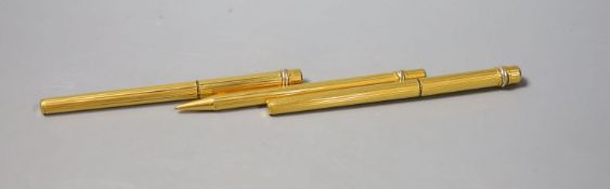 A Cartier gilt metal fountain pen, ball point pen and propelling pencil
