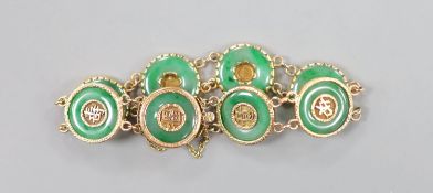 A Chinese yellow metal (stamped 18) and pierced eight stone jade disc set bracelet, with central