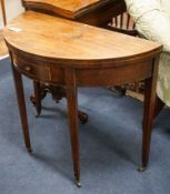 A Georgian mahogany demi-lune card table, with folding top on square tapered legs, width 86cm, depth