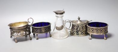 An Edwardian pierced silver oval mustard pot, with liner, a set of three similar salts, one