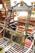 A 19th century Gothic style mahogany three-tier wall bracket with a small glazed cupboard under,