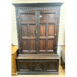 A carved oak cupboard, enclosed by panelled doors, bearing monograms and dated 1601, width 138cm,