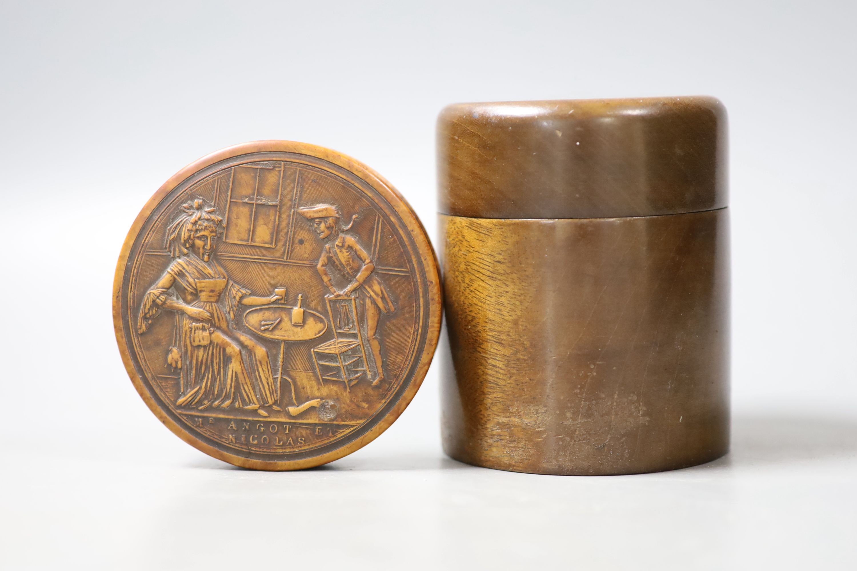 A French press moulded burr wood snuff box of circular form, decorated in semi-relief to the top