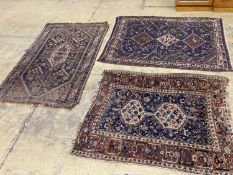 Three antique Caucasian blue ground rugs, largest 154 x 114 cms.