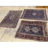 Three antique Caucasian blue ground rugs, largest 154 x 114 cms.