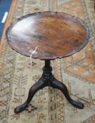A Georgian circular mahogany occasional table, having piecrust top on vase-shaped column and