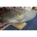 A contemporary oval glass top coffee table on simulated carved stone base, width 118cm, depth