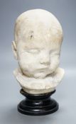 A 19th century memento mori plaster bust of an infant, on ebonised socle22cm