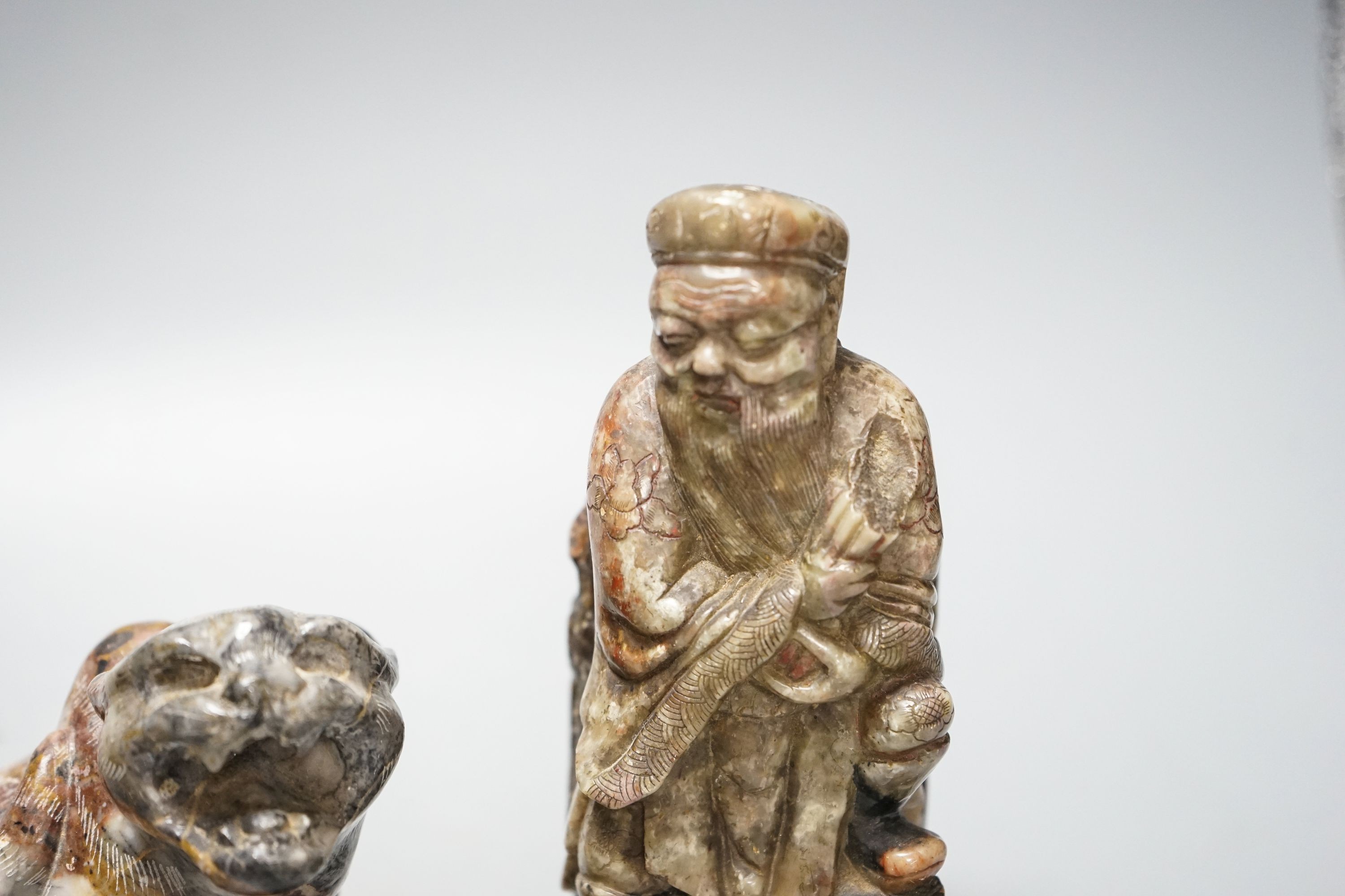 A pair of Chinese soapstone figures of immortals, modelled seated on rocky bases and a similar - Image 2 of 2