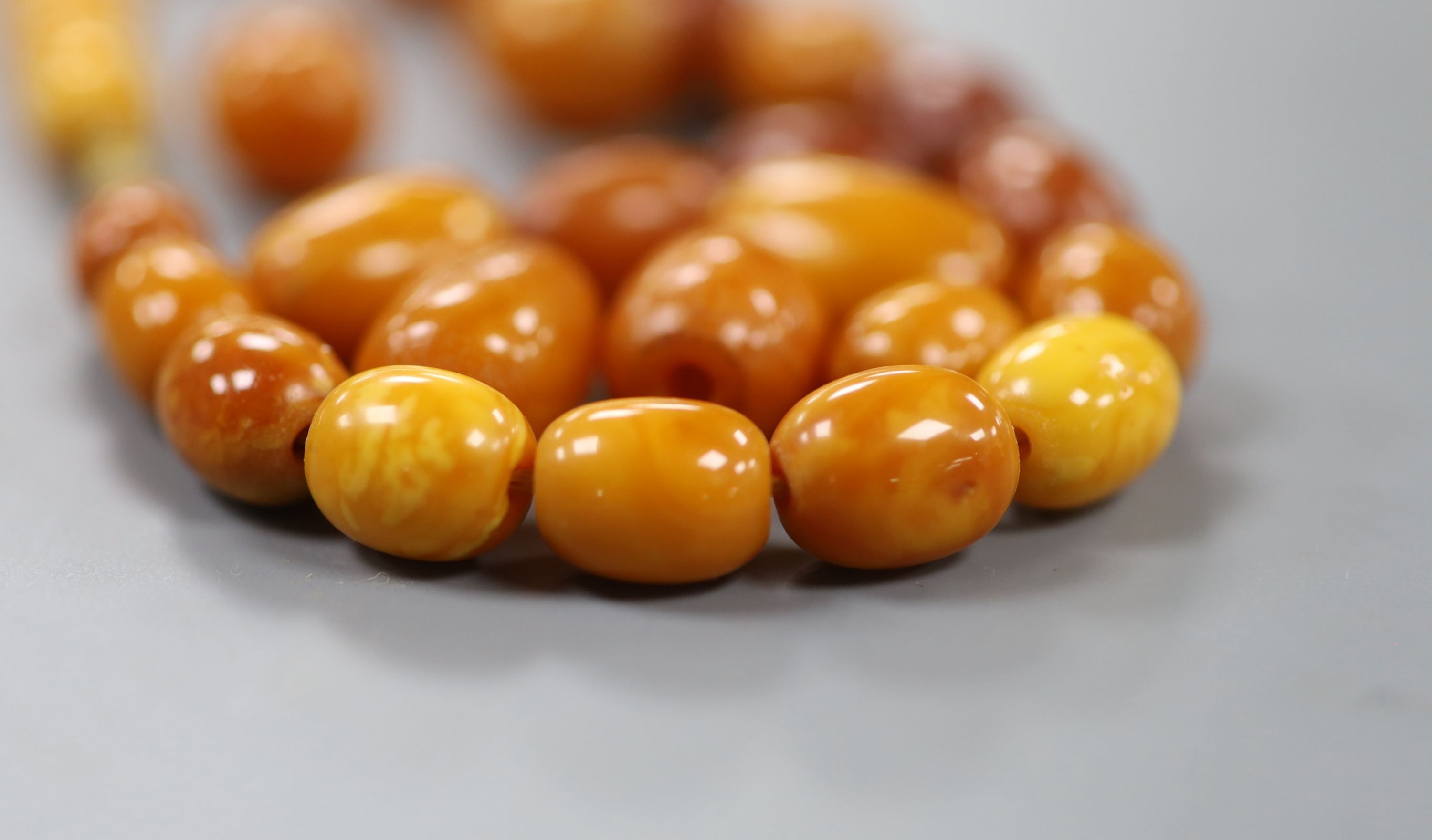 A single strand graduated oval amber bead necklace, 47cm, gross weight 33 grams. - Image 2 of 2