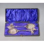 A cased pair of early 20th century Hanau white metal serving spoons, with embossed bowls and yacht