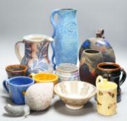A group of studio pottery jugs, mugs, and other vessels to include –a tall Nancy Angus jug, an