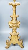 An 18th century Italian giltwood candlestand, foliate and scroll-carved,on tripartite base (