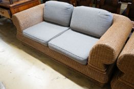 A pair of contemporary rattan conservatory settees, with grey fabric cushions, seats and backs,