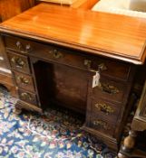 A George III and later mahogany kneehole desk, fitted seven drawers and recessed cupboard on ogee