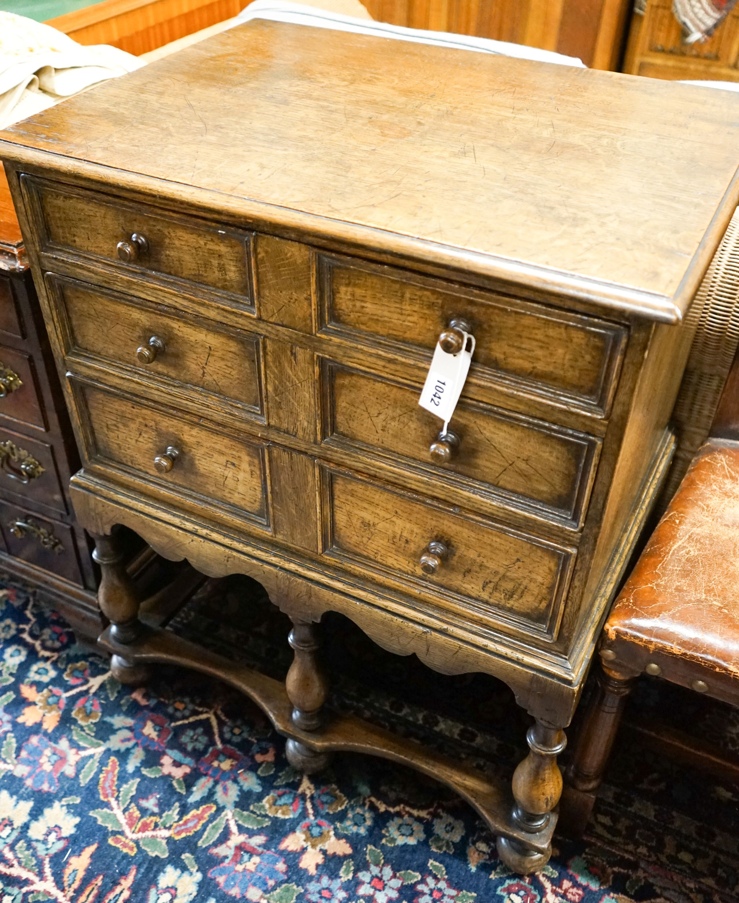 A 17th century style small oak chest on stand,the base fitted three long drawers on turned