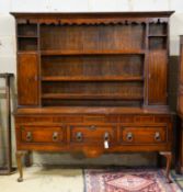 An 18th century oak and mahogany crossbanded dresser,having a boarded three-tier plate rack over a