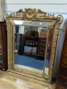 A large 19th century French gilt and gesso frame, bevel edged mirror with cushion margin, plated and