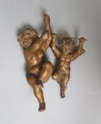 Two carved beech figures of cherubs27cm