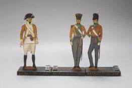 Three painted wood ‘foot officer’ menu holders19cm